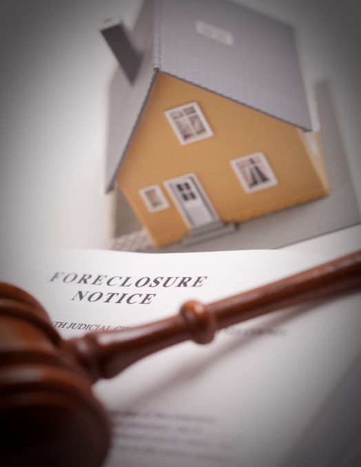 A judge 's gavel sitting on top of an foreclosure notice.