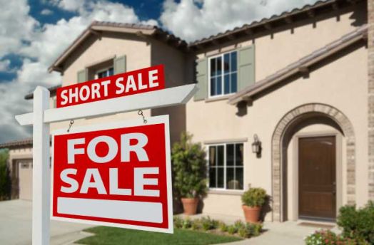 A short sale sign in front of a house.