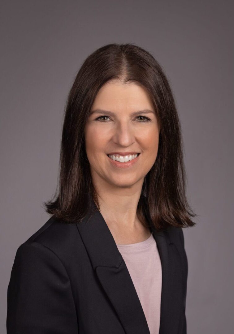 A woman in a black jacket and pink shirt